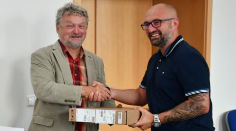 Náměstek hejtmanky Jihočeského kraje Zdeněk Dvořák předává zástupci TJ Sokol Radomyšl elektroniku pro hokejové zápisy.