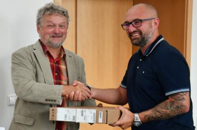 Náměstek hejtmanky Jihočeského kraje Zdeněk Dvořák předává zástupci TJ Sokol Radomyšl elektroniku pro hokejové zápisy.